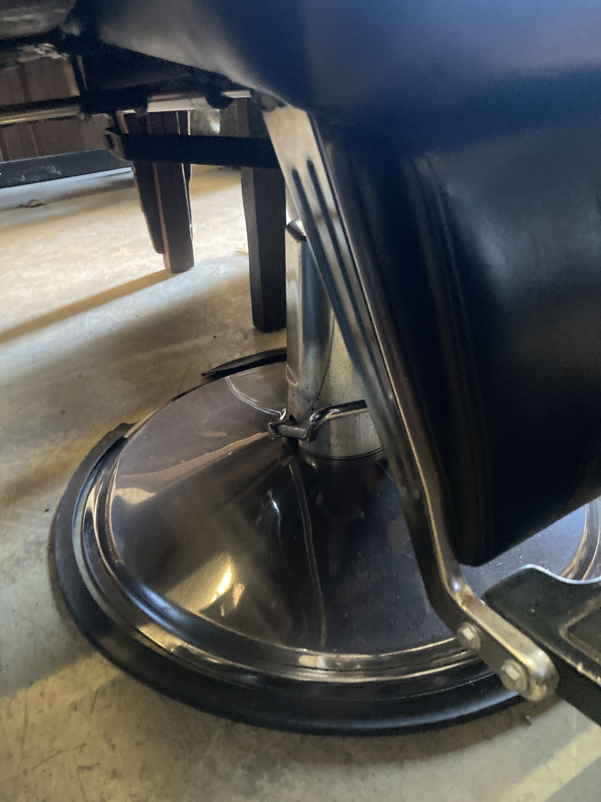 A black leatherette adjustable barbers chair, width 70cm, height 120cm
